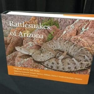 A book about rattlesnakes is sitting on the table.